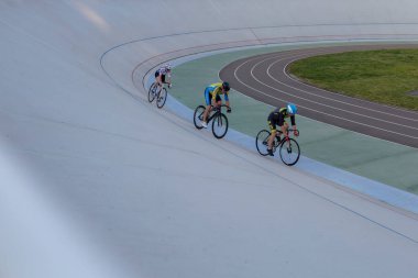 Ukrayna 'nın başkenti Kyiv' de bisiklet pistinde üç bisikletçi yarışıyor.