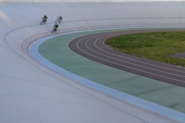 Ukrayna 'nın başkenti Kyiv' de bisiklet pistinde üç bisikletçi yarışıyor.