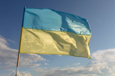 Ukrayna bayrağı mavi gökyüzünün arka planında rüzgarda dalgalanıyor. Ukrayna bağımsız bir devlet.