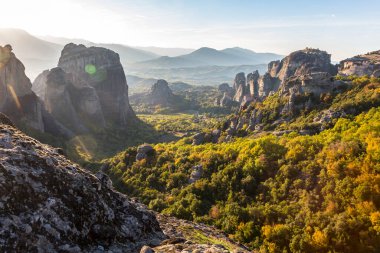 Gün batımında Kalabaka vadisinde kaya oluşumundaki mucizevi manastırdan Pindos Dağları 'nın yanındaki Meteora, Yunanistan manzarası..