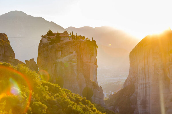 The Greek miraculous monastery in a sun light on the rock formation during sunset, Meteora, Greece. Mysterious hanging over rocks monasteries near Kalabaka