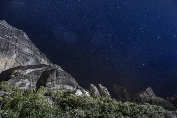 The conglomerate formation of Meteora during night, dark sky with stars. Central Greece