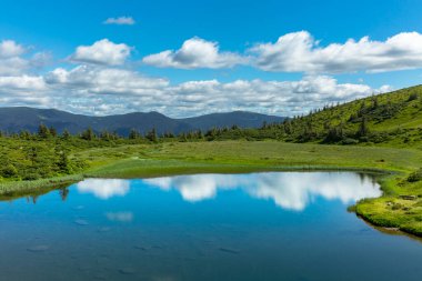 The water surface of a blue lake against the background of the Gorgan mountain range, the Carpathians