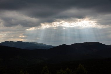 Radiating evening sun Through the Clouds in the mountains, with view on Dovbushanka mountain range, Carpathians