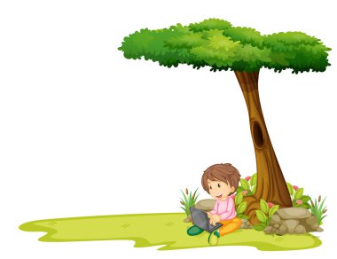 bir ağacın altında bir dizüstü bilgisayar ile bir çocuk