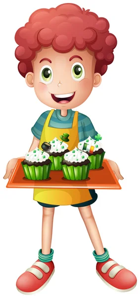 A boy holding a tray of cupcakes — Stock Vector