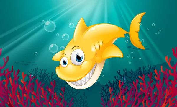 Un tiburón amarillo sonriendo bajo el mar — Vector de stock