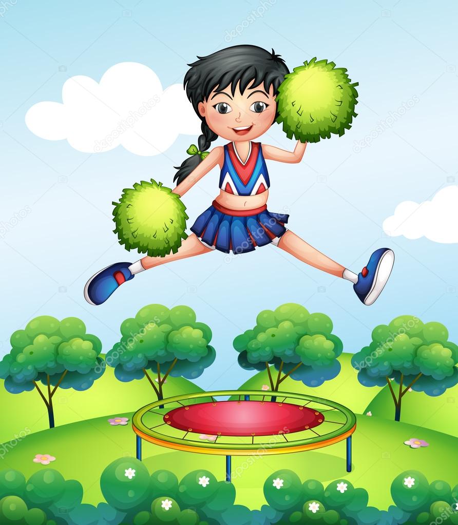 A cheerleader jumping with her green pompoms above a trampoline