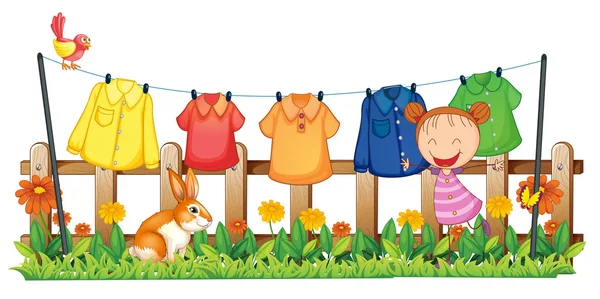 A little girl in the garden with hanging clothes — Stock Vector