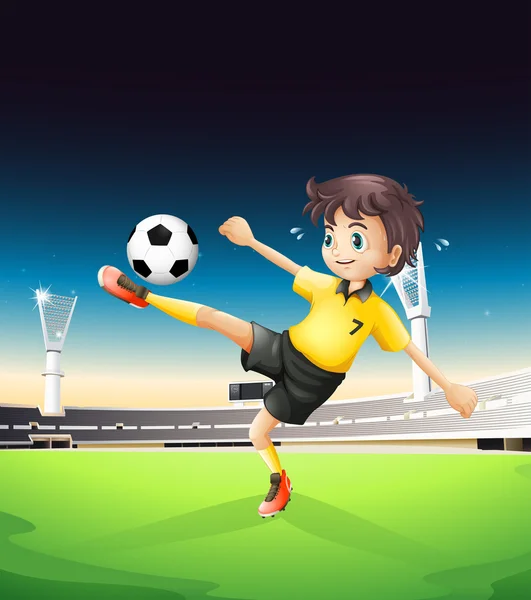 A boy in a yellow uniform playing soccer in the soccer field — Stock Vector