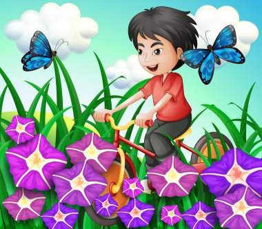 A boy biking in the garden with flowers and butterflies