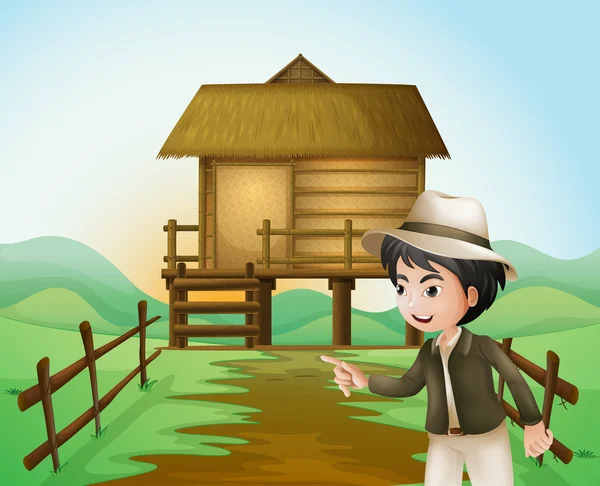 A boy with a hat standing near the nipa hut — Stock Vector