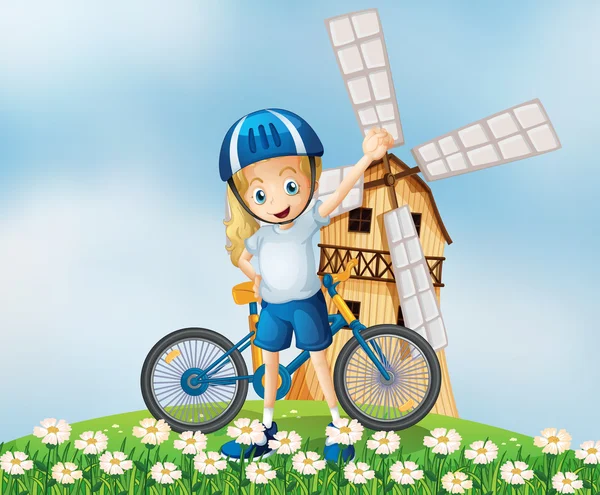 En kvinnlig cyklist står på kullen med en väderkvarn — Stock vektor