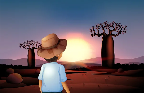 A boy with a hat watching the sunset in the desert — Stock Vector