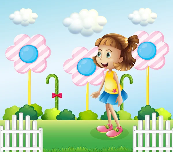 A little girl near the wooden fence with giant candies — Stock Vector