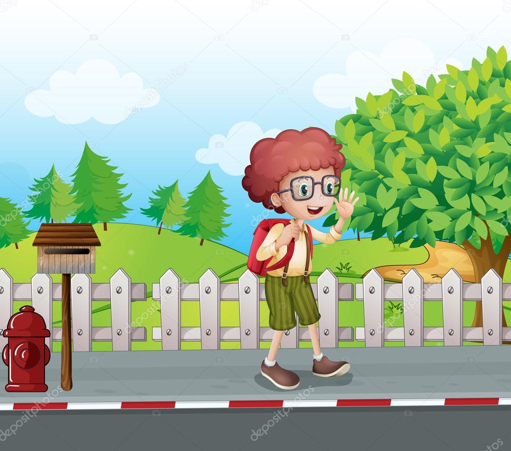 A boy with a backpack walking near the mailbox