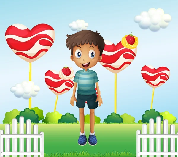 A smiling young boy standing in the garden with giant heart loll — Stock Vector
