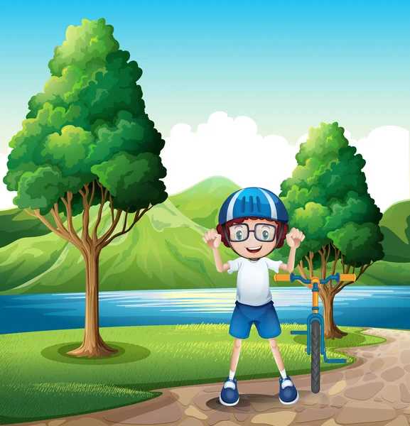Mladý chlapec a jeho kolo hračka stojící poblíž stromů v řeky — Stockový vektor