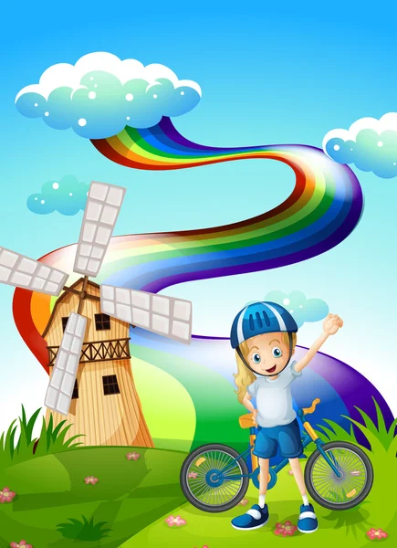 A young biker at the hilltop with a windmill and a rainbow — Stock Vector