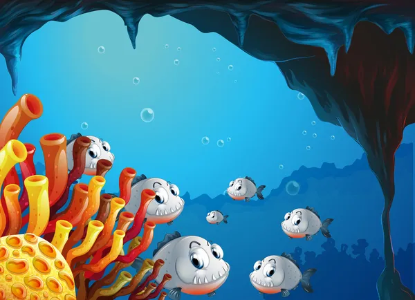 Una escuela de peces dentro de la cueva del mar — Vector de stock