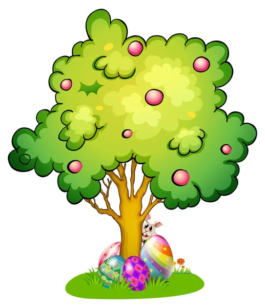 A bunny and eggs under the tree — Stock Vector