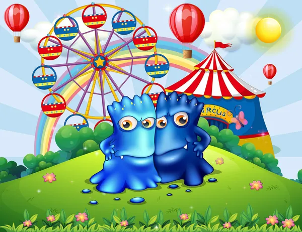 Two monsters at the hilltop with an amusement park — Stock Vector