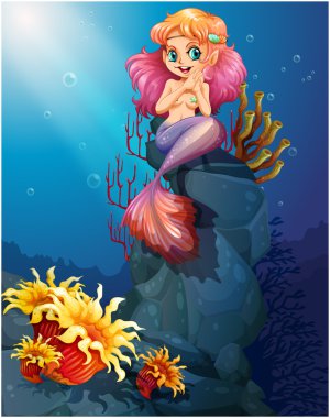 A smiling mermaid sitting above the rocks clipart