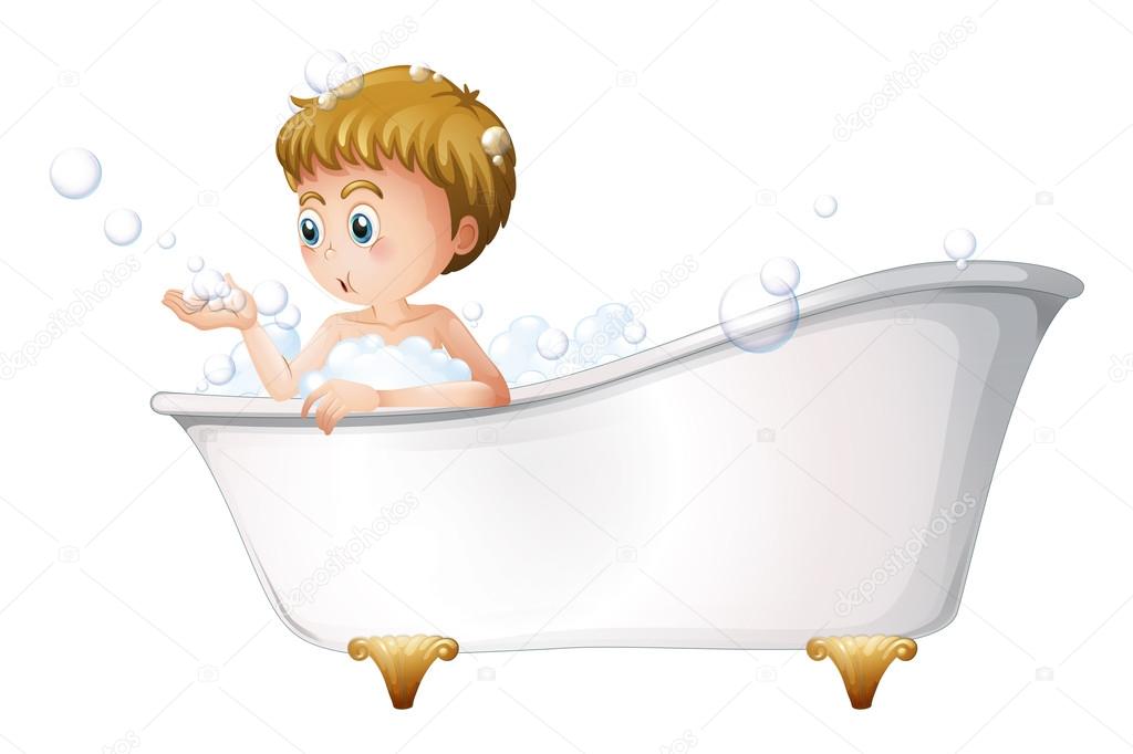 A boy playing at the bathtub while taking a bath