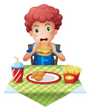 kıvırcık saçlı bir çocuk bir fastfood restoranda yemek