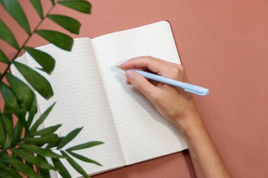 Kalemle el ve bulanık önplanlı açık defter