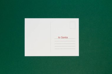 Yeşil arkaplanda noel kartı olan zarf.