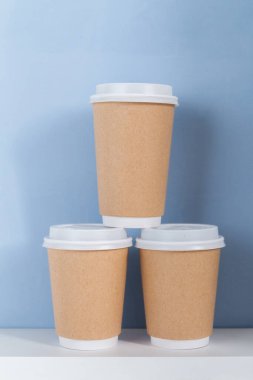 Açık mavi arkaplana karşı gitmek için boş kağıt bardak