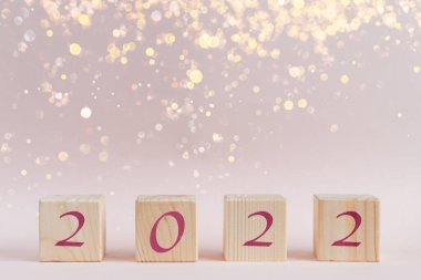 Tahta küp piramidi, yeni yıl numaraları ve ışıltılı ışıltılarıyla bokeh