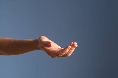 Avuç içinde bir şey var, mavi arka plan.