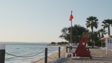 Sahildeki kırmızı bayrak, turistlerin güçlü dalgalar üzerinde denizde oynamalarının yasaklandığının bir işareti.