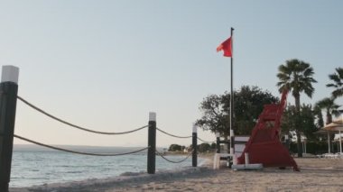 Sahildeki kırmızı bayrak, turistlerin güçlü dalgalar üzerinde denizde oynamalarının yasaklandığının bir işareti.