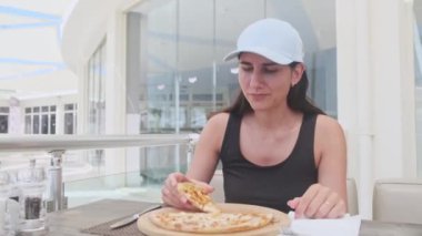 Şehirdeki restoranda abur cubur dilimleri yiyen yakın bir kadın.