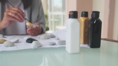 Doğada resim çizen yetenekli bir ressam. Rüzgarlı bir günde taş boyayan yaratıcı bir kızın portresi. Düşünceli ressam, boyaya benziyor. Yakından mükemmel renkler buluyor. Sanat yaratma kavramı