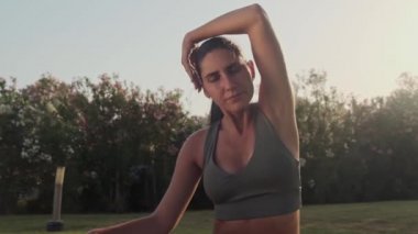 Kadınların boyun ağrısı var, omuz ağrısı, parkta, yoga egzersizi sırasında, sağlık konsepti, yavaş çekim