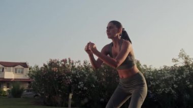 Sport woman in sportswear performing yoga pose outdoors. Athletic girl stretching in park. Fitness woman doing yoga exercises on green grass. Sporty girl workout outdoor. Slowmotion
