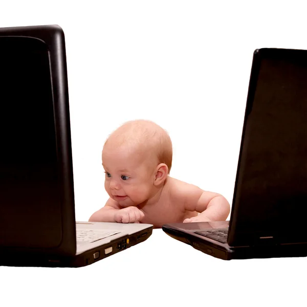 Bambino con gli occhi blu che lavora su due computer portatili allo stesso tempo . — Foto Stock