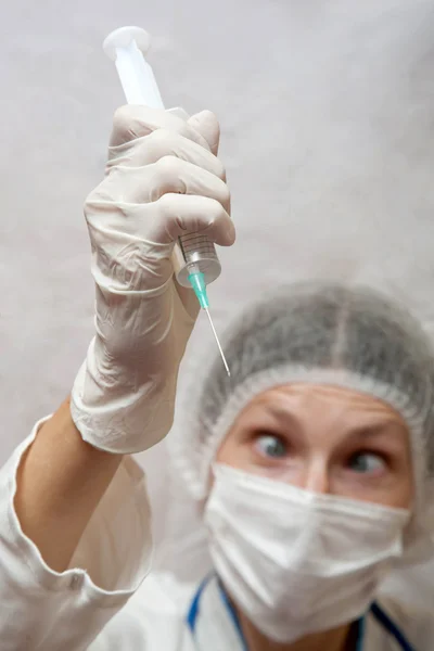 Crazy doctor with wild eyes and a syringe in his hand — Stock Photo, Image