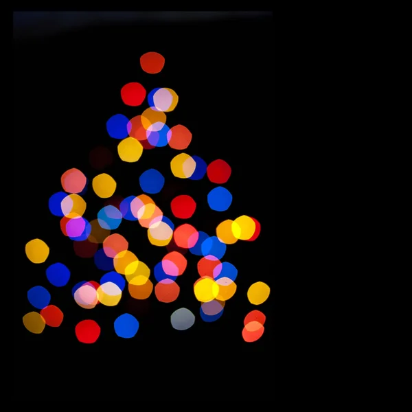 Olorful cirklar bokeh av christmaslight i form av en julgran — Stockfoto