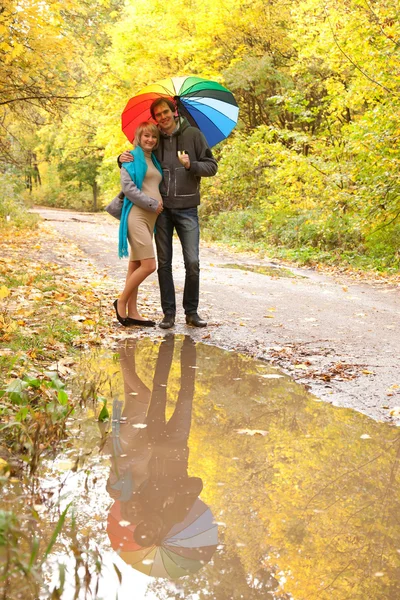 Happy pregnant woman and man walking in autumn forest — Stock Photo, Image