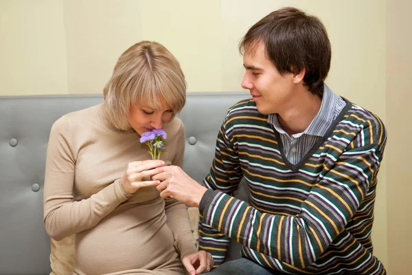 Mann schenkt seiner schwangeren Frau einen Blumenstrauß — Stockfoto