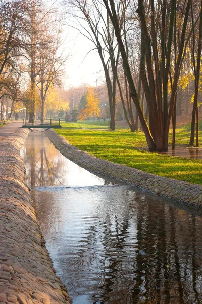 Stream, paved path and benches in the city park — Stock Photo, Image