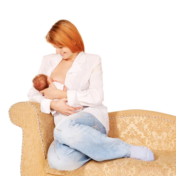 Mãe amamentando bebê recém-nascido no sofá — Fotografia de Stock