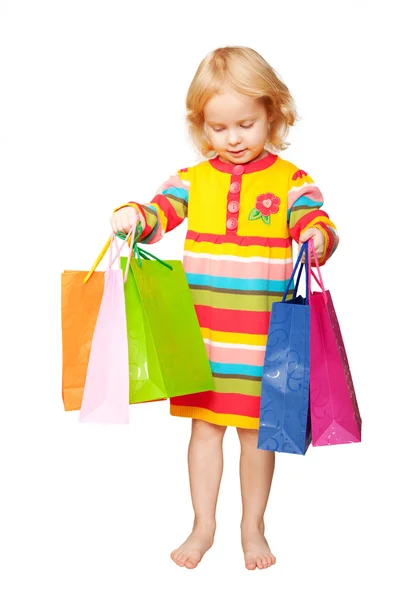 Heldere gelukkig kind met shopping tassen in de hand. — Stockfoto