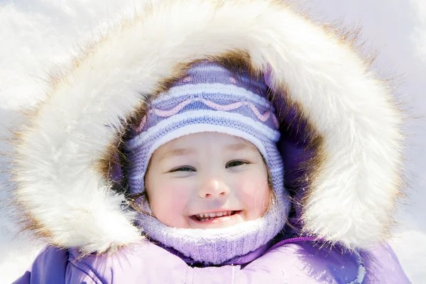 Retrato de inverno. Feliz bebê sorridente deitado na neve — Fotografia de Stock