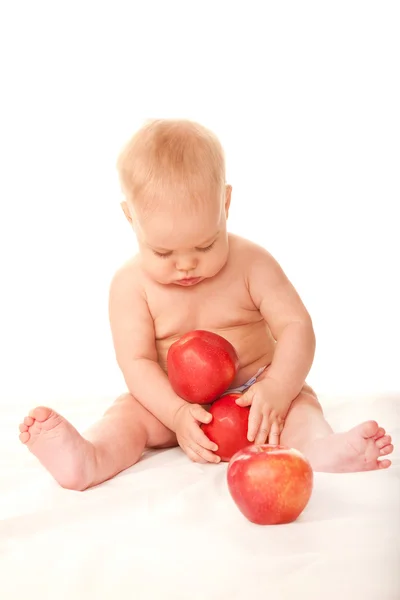 Bebê brincando com maçãs vermelhas — Fotografia de Stock